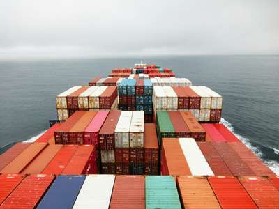 Containerschiff, dass farbenfrohe Container über den Ozean transportiert, illustrierend für schnelle und minimale Python Docker Container Images, die uv verwenden.